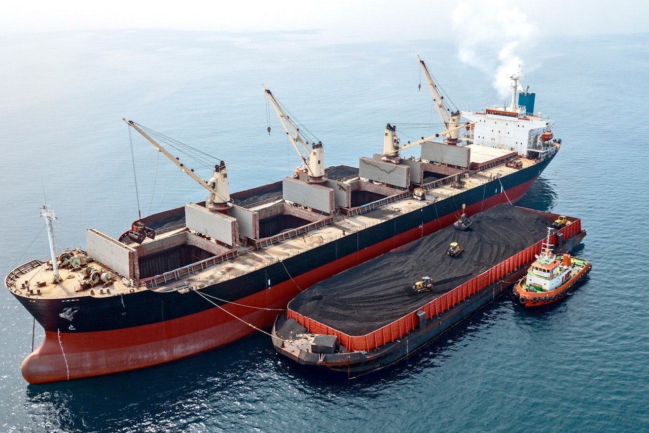 Photo depicts Loading Unloading Coal From Barge to Mother Vessel