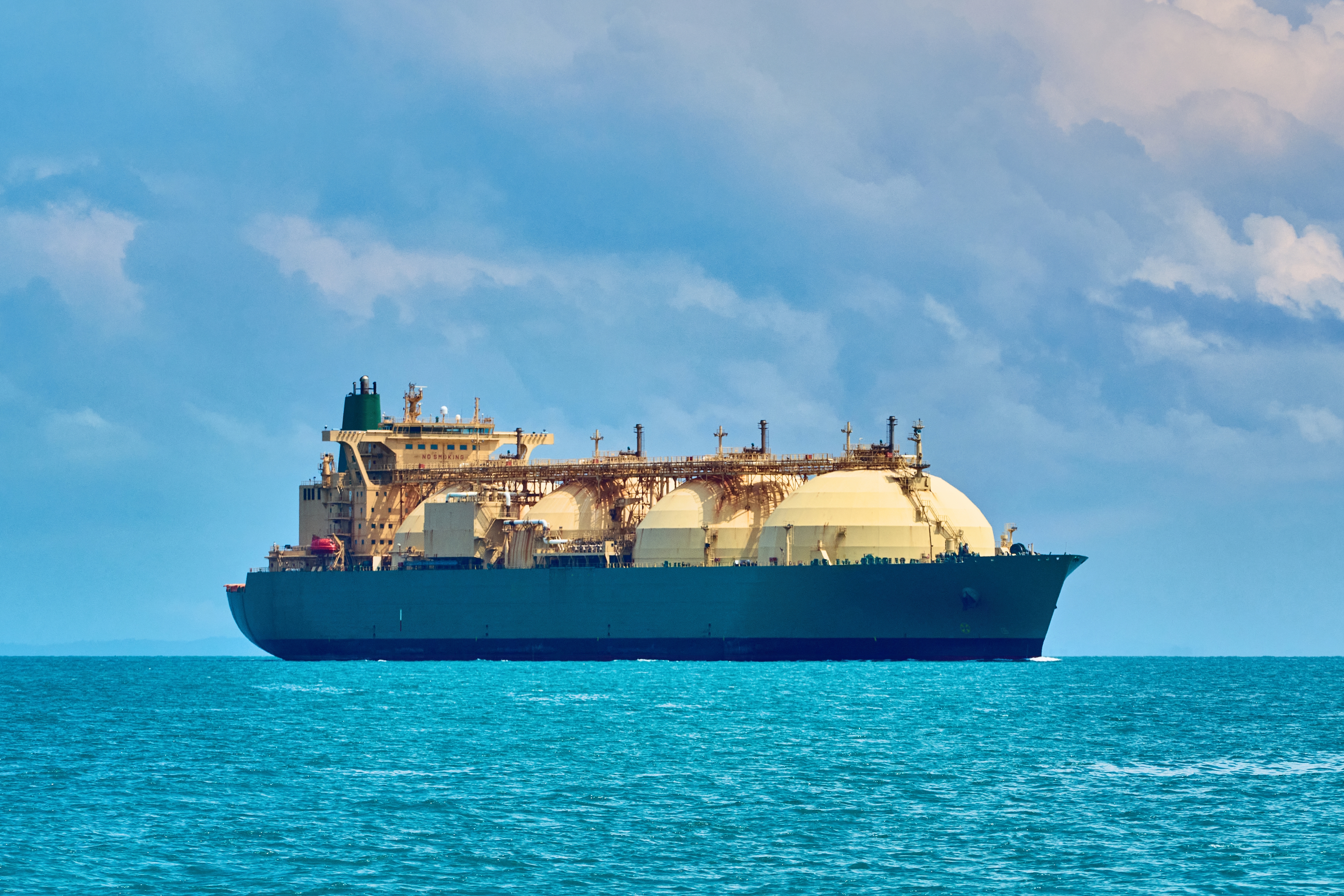 Frontal view from the side of an LNG tanker truck moving along the Singapore Strait