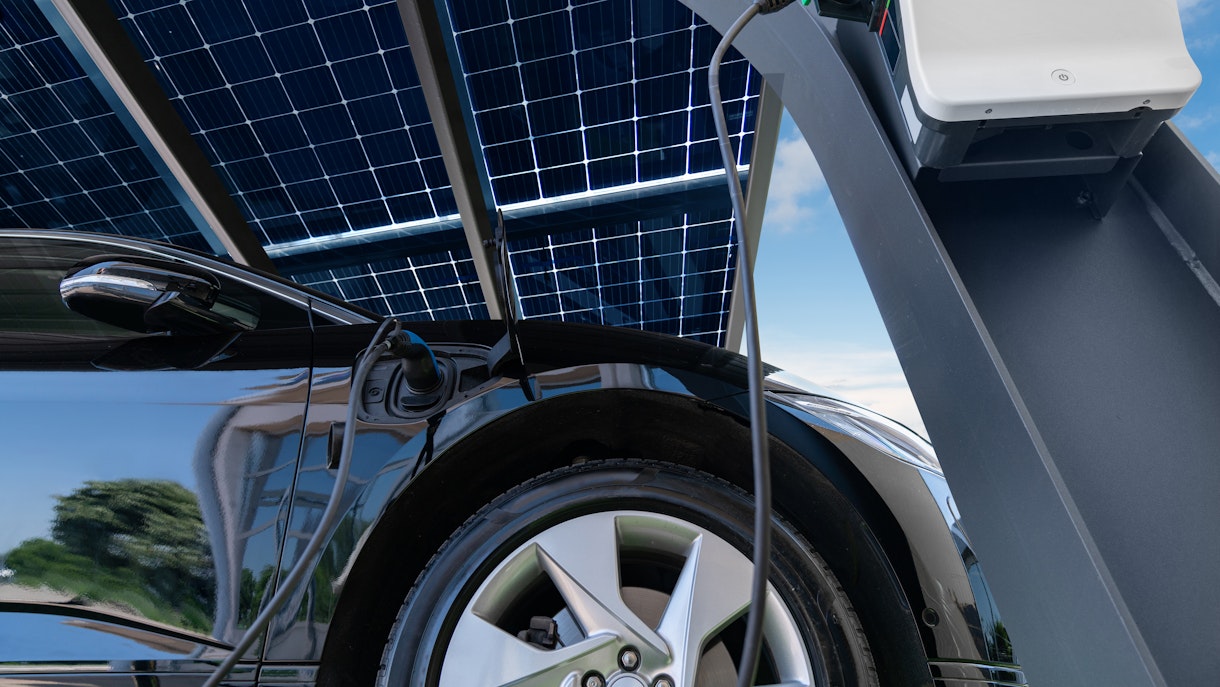 El informe Gevo 2023 cubre un automóvil eléctrico que se carga bajo paneles solares