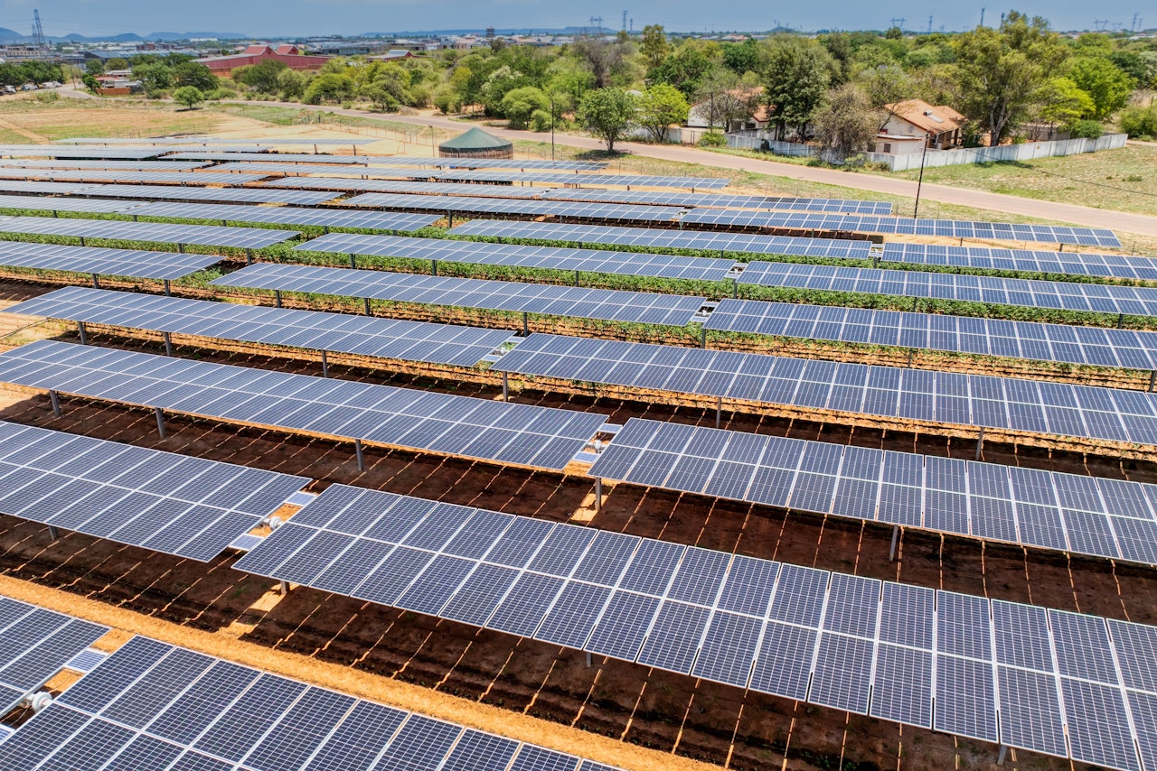 Photo depicts of Solar panels on tomato field for agriculture, development of rural areas and cities in Africa.