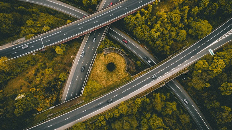 Image is an ariel photo of an intersection on a highway with trees