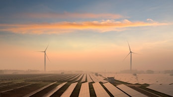 Photo depicts a solar panels and windmills in the power plant
