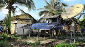Cover Of Access To Electricity Commentary Solar Panels In Tropical Setting