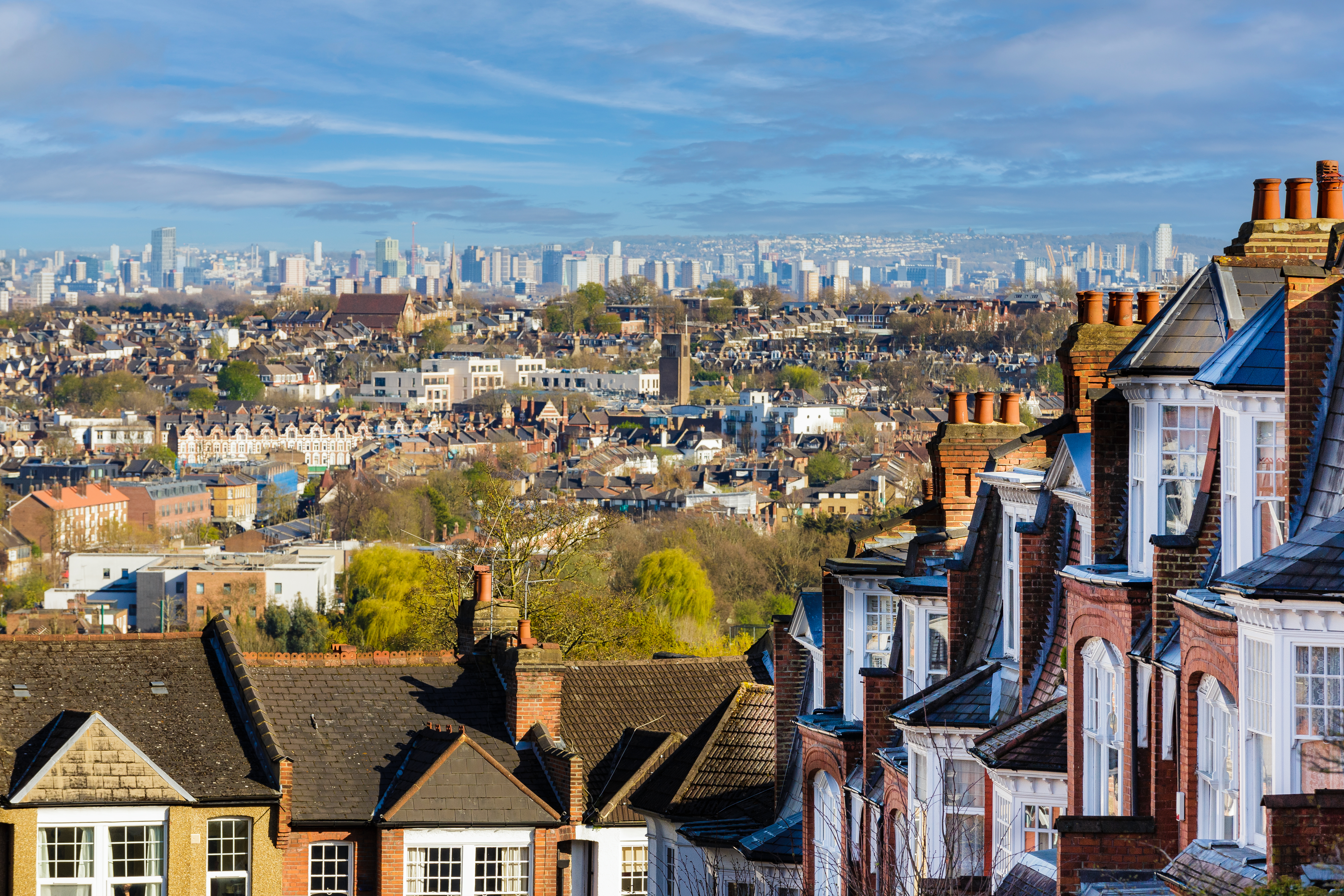 photo depicts Panoramic view across the city of London, taking in huge residential districts, with the ultra modern architecture of the skyscrapers of downtown visible on the horizon.