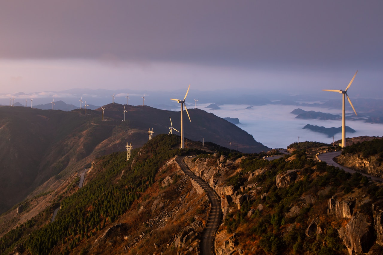 Wind Turbines On Top Of Mountain With Clouds Underneath Shot At Sunrise In Kuocang Mountain Zhejiang China Shutterstock 1715606569