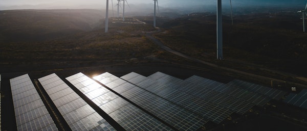Investment Topic Page Cover Image Windwills In The Background With Solar Panels At The Foreground