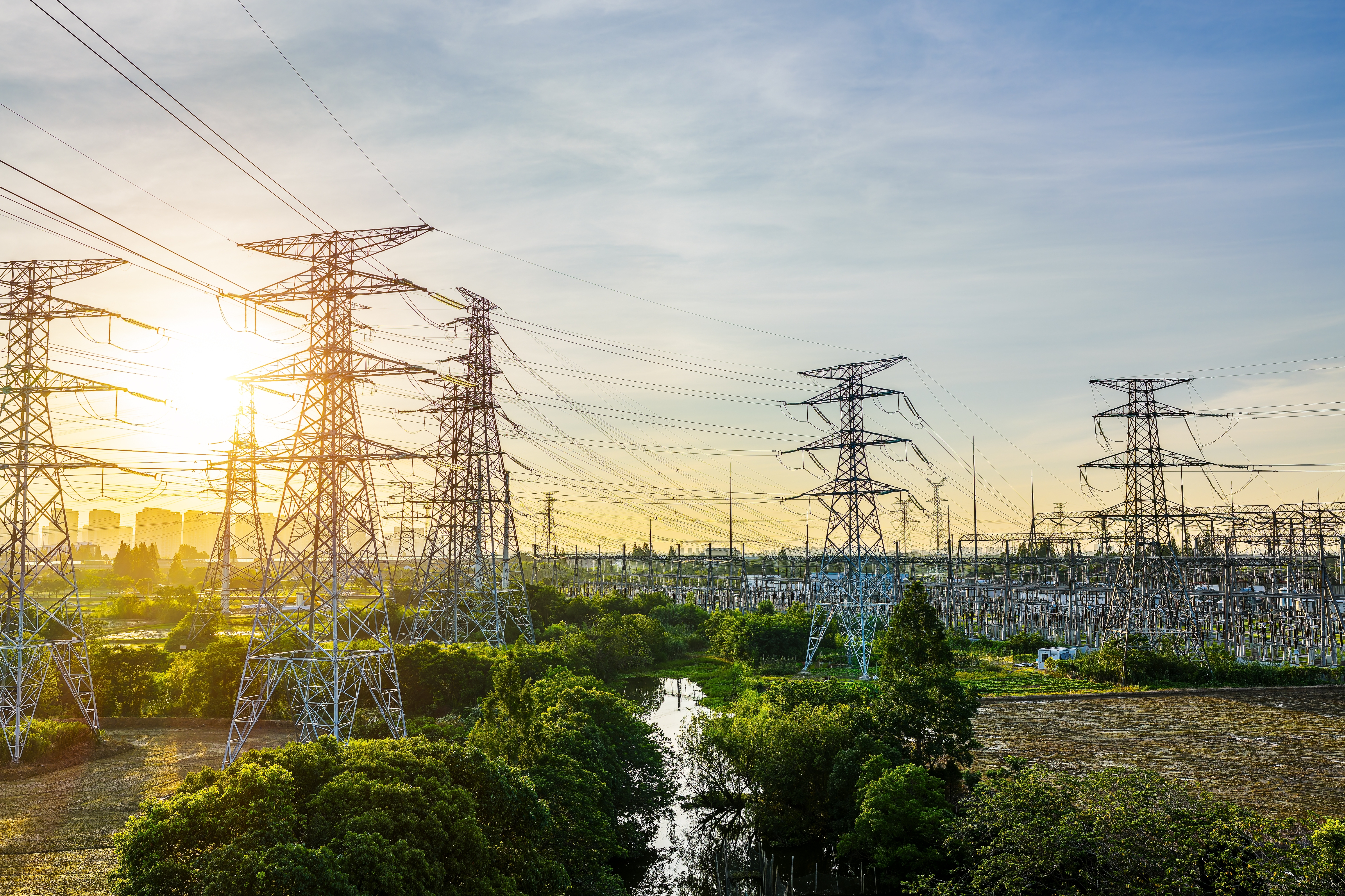 Photo depicting high voltage transmission towers and electrical substation at sunset. shutterstock 2750775877