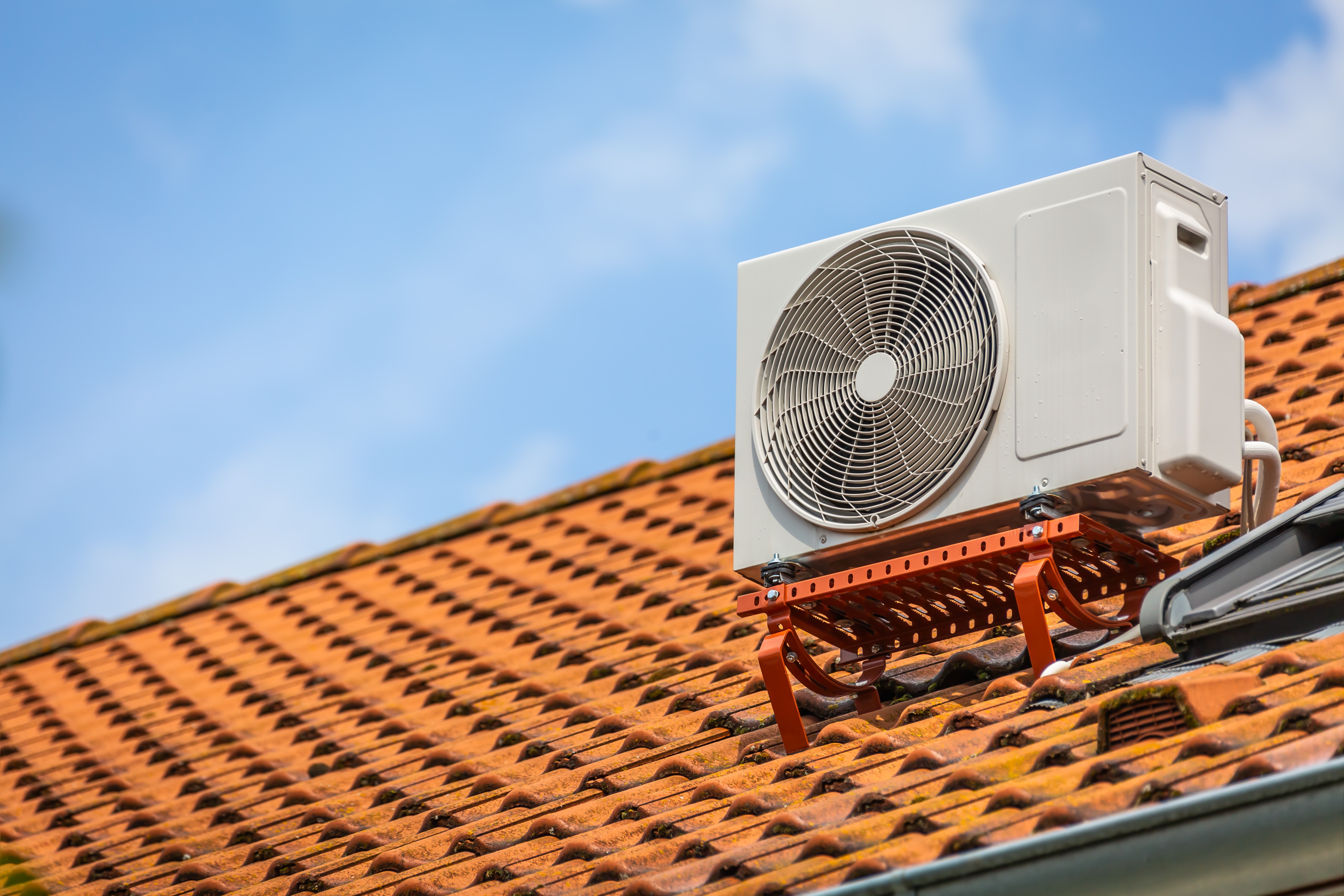 photo depicts a Dual inverter, combination of air conditioning compressor and heating pump, installed on a family home roof.