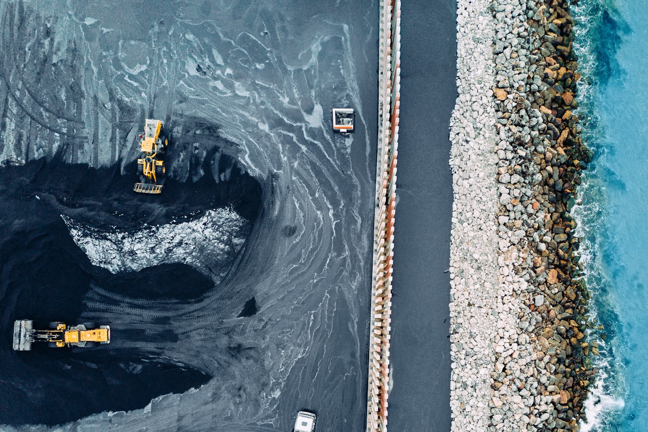 An aerial view of a coal mine next to the ocean