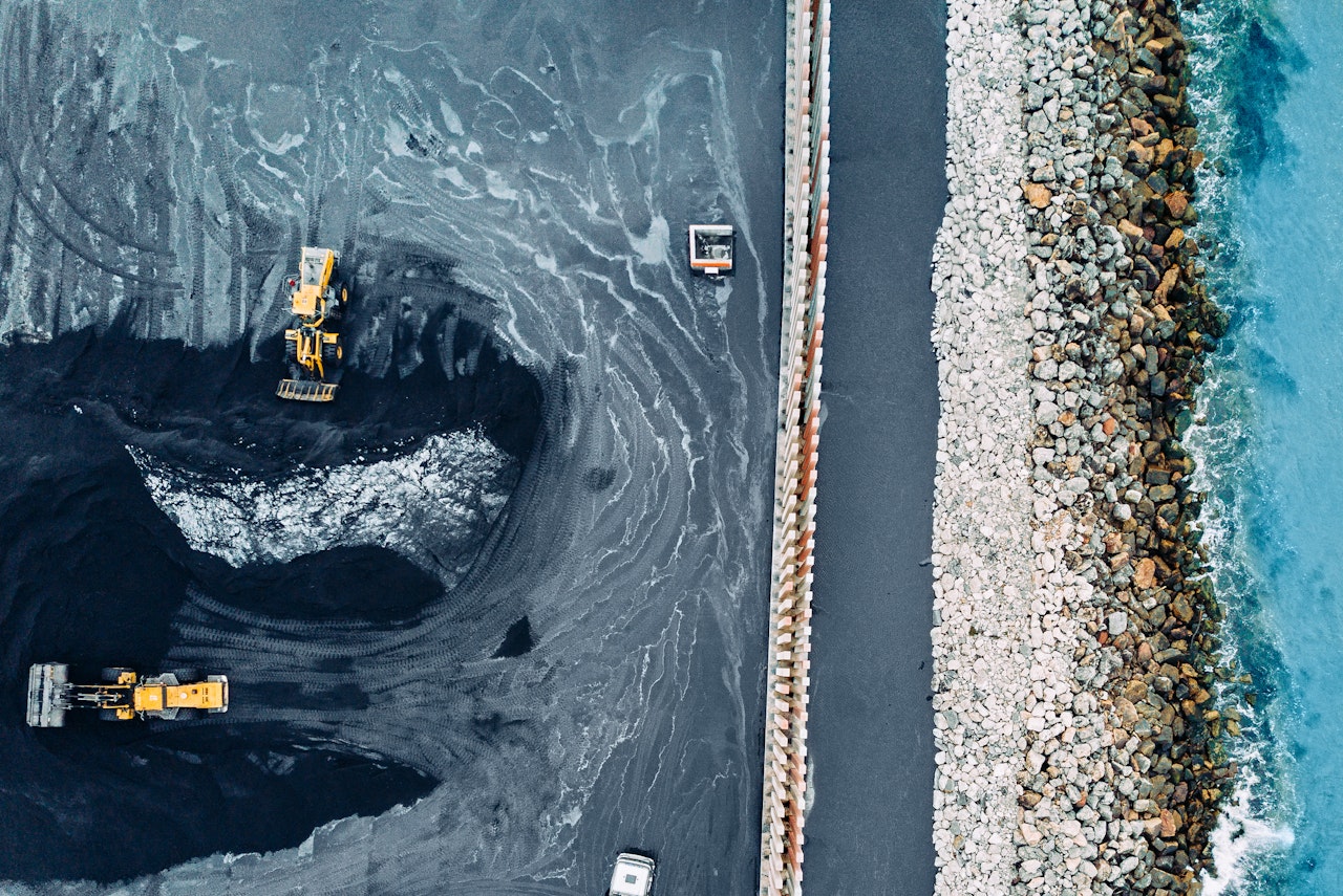 An aerial view of a coal mine next to the ocean