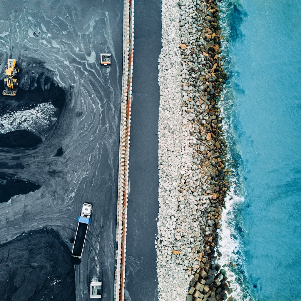 An aerial view of a coal mine next to the ocean