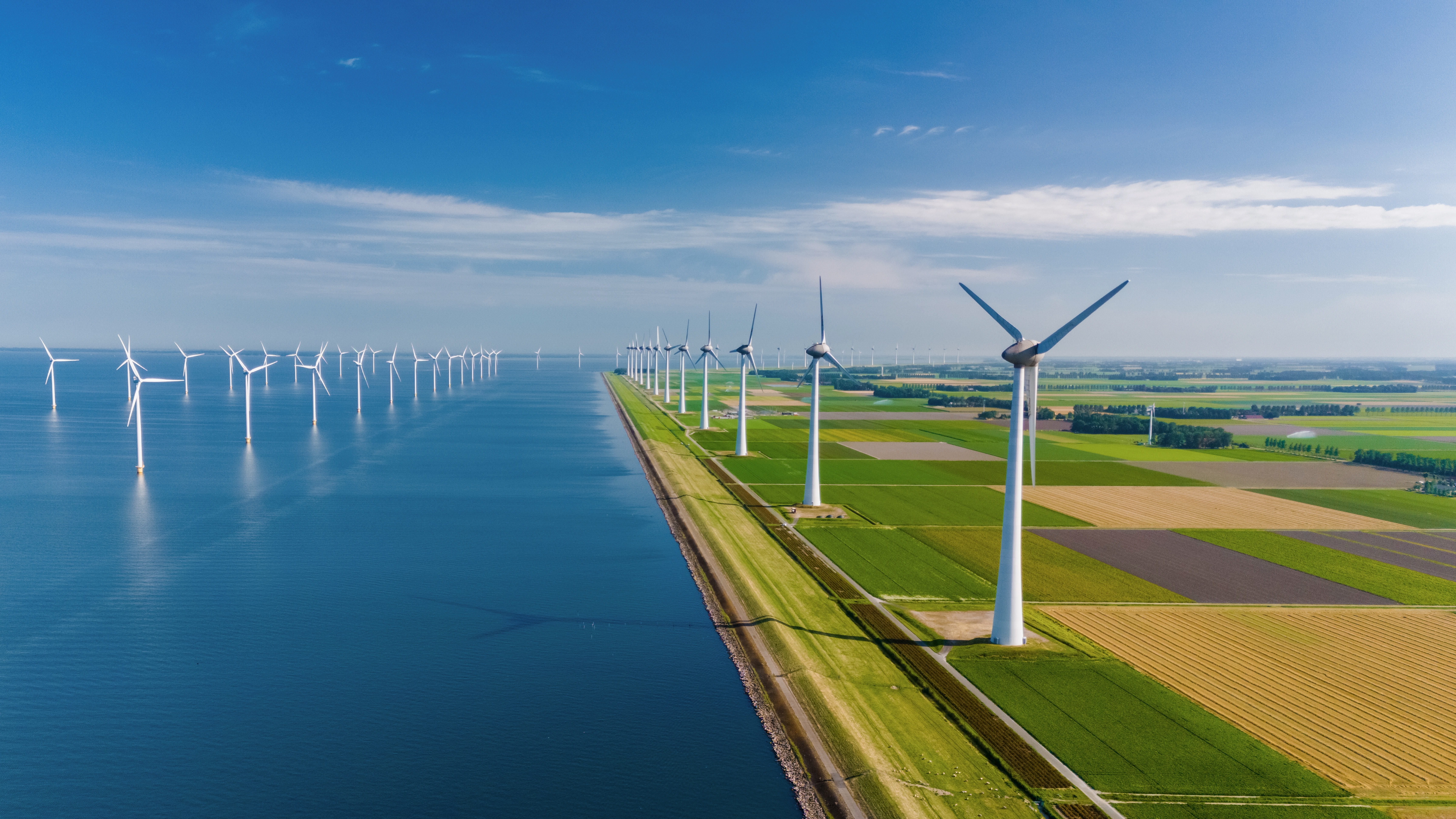 Photo showing windmill farm in the ocean and on land at the dike NL shutterstock 2502875921
