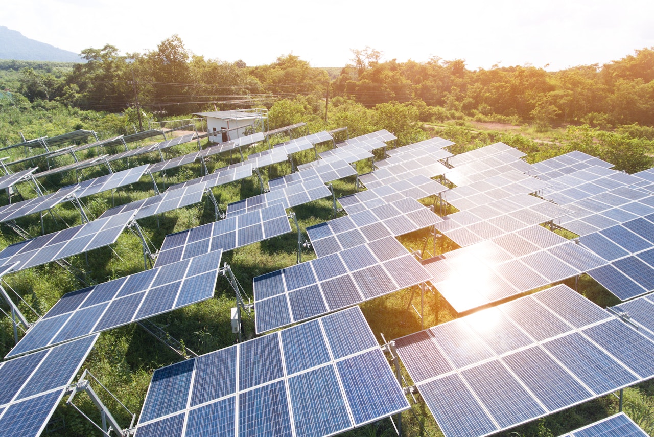 Photo depicts Solar Power Station in the green spring Nature,Solar panel Clean energy thailand