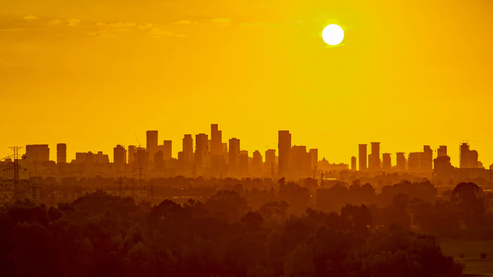 Keeping cool in a hotter world is using more energy, making efficiency more important than ever_Heat wave over a city skyline