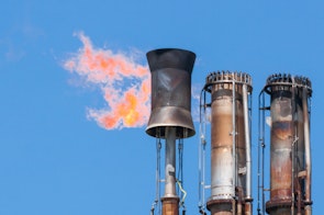 Photo depicts Burning oil flare on a blue sky