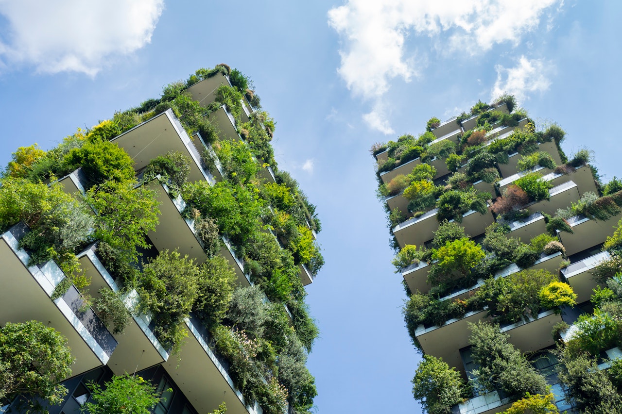 Photo of a modern and ecological skyscraper with many trees on each balcony