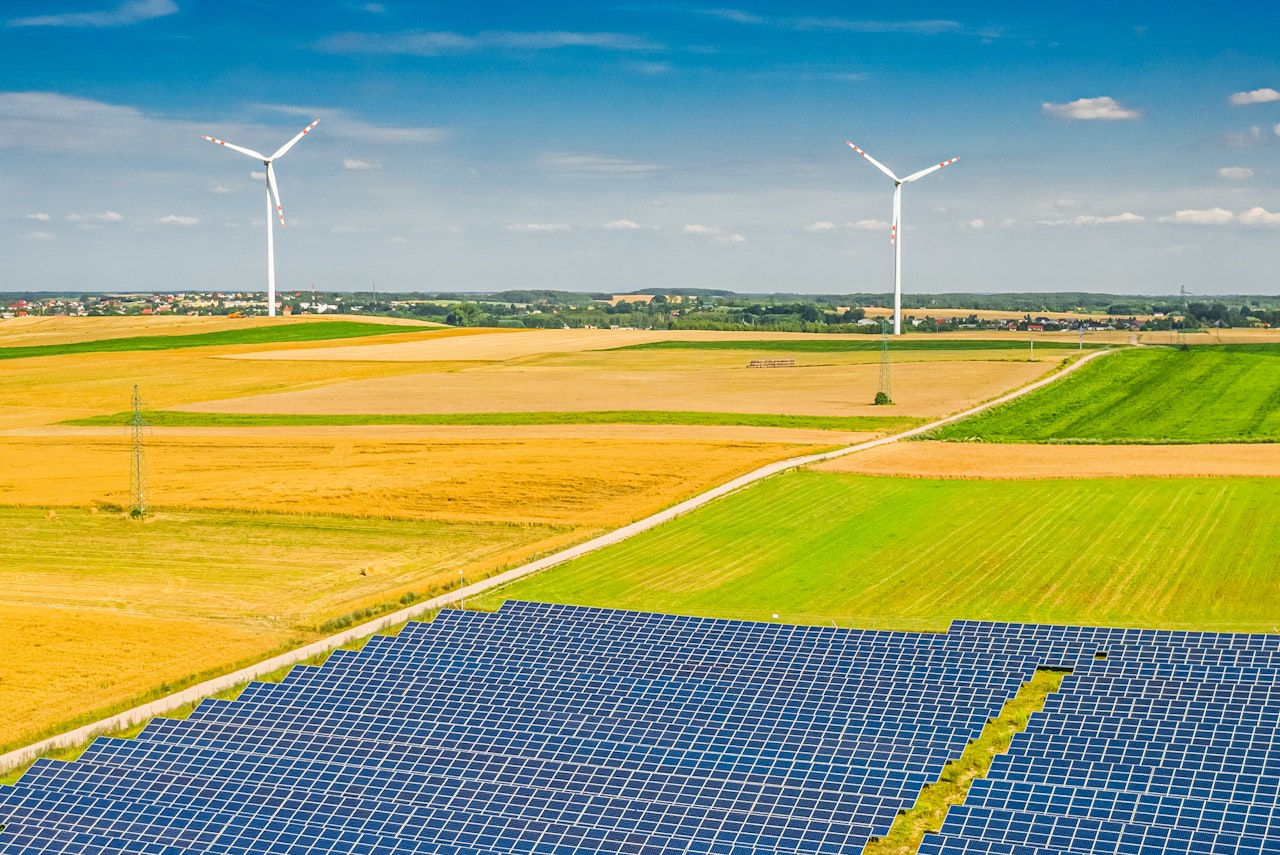 Solar panels and wind turbines in a field, cover of Renewables 2021