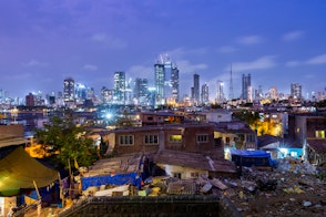 Night skyline of Mumbai photographed from Worli fort with the village in the foreground. Encroachment and development in the same frame.
