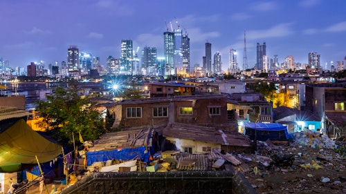 Photo depicts Night skyline of Mumbai photographed from Worli fort with the village in the foreground. Encroachment and development in the same frame.