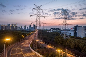 Photo depicts high-voltage power lines. high voltage electric transmission tower at sunset.